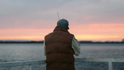 Angler drifting for smallmouth bass on a serene lake.