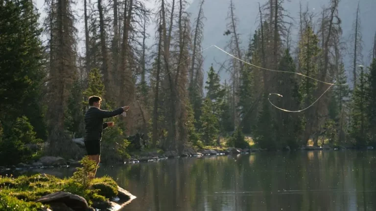 Flipping and Pitching for Bass: A Beginner's Guide 21 Angler flipping and pitching for bass in a serene alpine lake at sunrise.