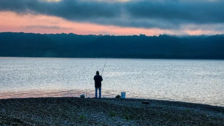 Shore Fishing Lake Monroe: A Beginner’s Guide to Success 5 Fisherman at sunrise casting from Lake Monroe shore, perfect for learning how to fish Lake Monroe from shore.